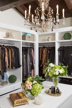 the closet is full of clothes and vases with flowers on them, including an orchid centerpiece