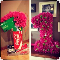 the letter i is made out of flowers and coca cola cans in front of it