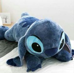 a large stuffed animal laying on top of a bed