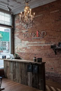 a brick wall with a chandelier hanging from it's ceiling in front of a window