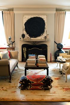 a living room filled with furniture and a fire place in front of a painting on the wall