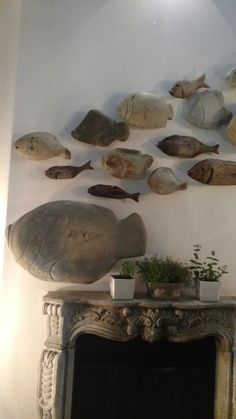 a fireplace with fish on the wall above it