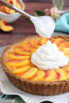 a piece of fruit tart with whipped cream being drizzled on top