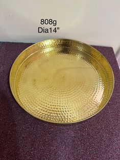 a gold plate sitting on top of a purple carpet