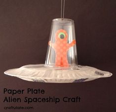 a paper plate alien spaceship craft hanging from a ceiling with the words paper plate alien spaceship craft on it