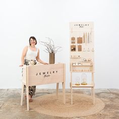 a woman standing next to a jewelry display