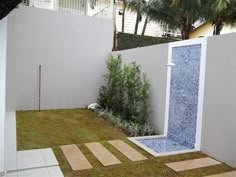 an outdoor shower in the middle of a small yard with grass and stepping steps leading up to it