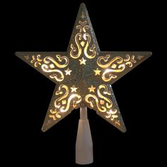 a lighted star with ornate designs on the top and sides, against a black background