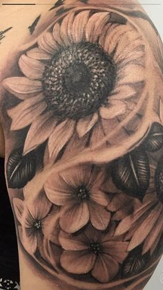 a woman's shoulder with sunflowers and butterflies on it