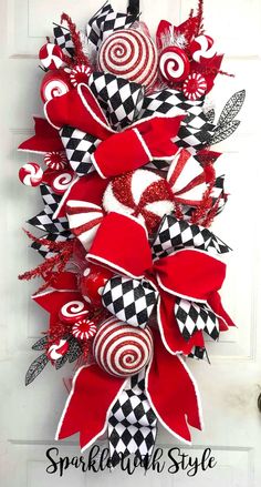 a red and black wreath with candy canes on the front door, hanging from a white door