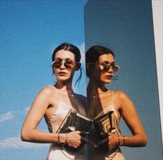 two women standing next to each other wearing sunglasses