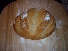 two loaves of bread sitting on top of a wooden cutting board covered in powdered sugar