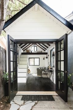 the inside of a small house with an open door and stairs leading up to it