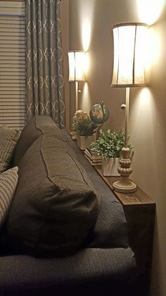 a living room filled with furniture and two lamps on top of each other next to a window