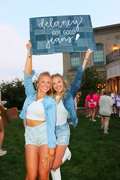 two young women holding up a sign that says welcome to the team