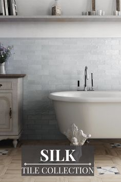 a white bath tub sitting next to a wooden shelf filled with books and vases