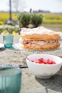 a sandwich and bowl of strawberries on a table