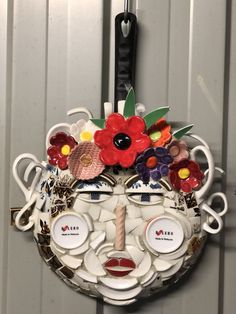 a plate with flowers on it hanging from the wall next to a pair of scissors