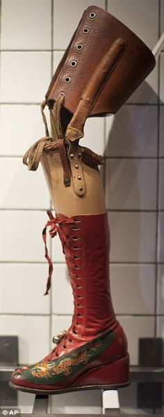 a pair of red boots sitting on top of a shelf