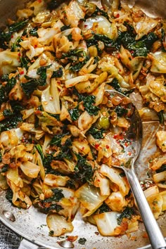 a skillet filled with stir fry vegetables on top of a table