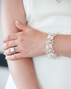 a close up of a person wearing a bracelet with pearls and diamonds on the wrist