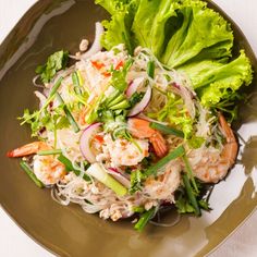 a green plate topped with salad and shrimp