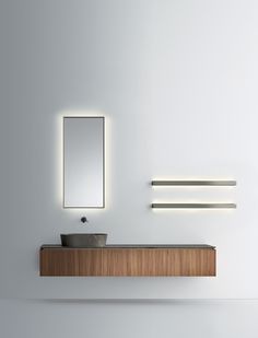 a bathroom with a sink, mirror and lights on the wall next to each other