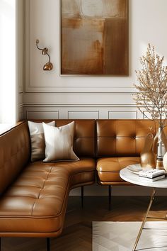 a living room with a couch, coffee table and vase on the floor in front of a painting