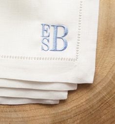 three folded napkins with the letter fb on them sitting on top of a wooden table