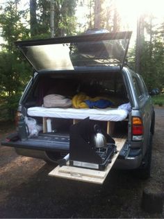 the back end of a truck with an open trunk and mattress on it's bed