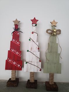 three small wooden christmas trees with decorations on them