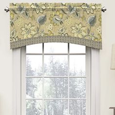 a window with a flowered valance hanging from it's side next to a lamp