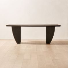 a large wooden table sitting on top of a hard wood floored floor next to a white wall