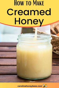 a jar filled with creamed honey sitting on top of a wooden table