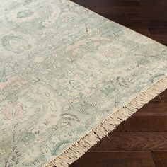 a large rug with fringes on top of it in the middle of a wooden floor