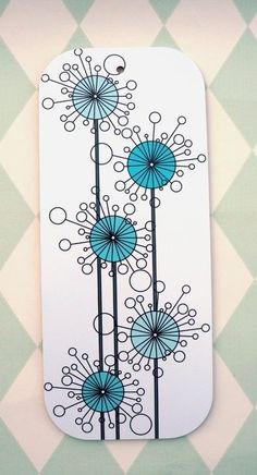 a white and blue tag with flowers on it sitting next to a checkered wall