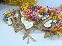 small bouquets of flowers tied together with twine and paper hearts on the table