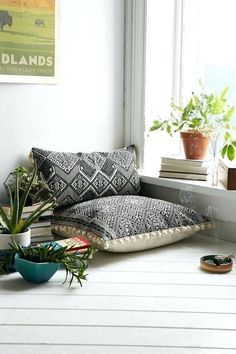 a window sill filled with books and plants next to a potted plant on top of a table