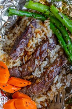 there is meat and rice with carrots on the plate