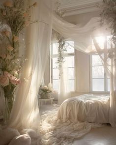 a white bedroom with sheer curtains and flowers on the bed