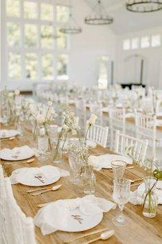 the tables are set with white linens and place settings