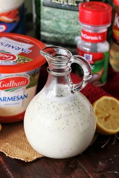 a glass bottle filled with cream sitting on top of a table next to other ingredients