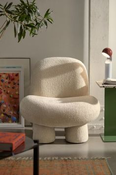 a white chair sitting on top of a table next to a potted plant