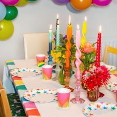 the table is set with colorful candles and plates