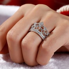 Delicate and romantic, this crown-shaped ring will utterly delight the queen of your heart. Fashioned in sleek sterling silver, this ring features open hearts and sparkling stones. Twinkling round stones, meaningful hearts and milgrain detailing complete this lovely style. A regal choice for your princess, this ring creates a romantic look. Carat Weight: 0.762 ctStone Size: 1.1,1.25,1.5 mmStone Type: Jeulia® StoneNumber of Stones: 31 Stone Color: Diamond WhiteStone Shape: RoundWeight: 5.63 gWidt Queen Crown Ring Design, Crown Ring Queen, Elegant Rings With Crown Design, Cubic Zirconia Diamond Ring With Crown Design, Luxury Crown Design Cubic Zirconia Rings, Luxury Cubic Zirconia Rings With Crown Design, Elegant Round Crown Anniversary Ring, Elegant Wedding Rings With Round Crown, Elegant Silver Ring With Round Crown