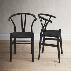 two black chairs sitting next to each other on a wooden floor