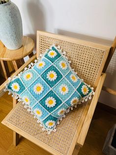 a crocheted cushion sitting on top of a wooden chair