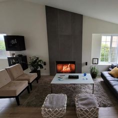 a living room with couches and a fire place in the middle of the room