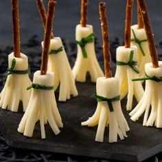 small marshmallows with green ribbon tied around them on a black plate,