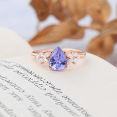 a tan and white diamond ring on top of an open book